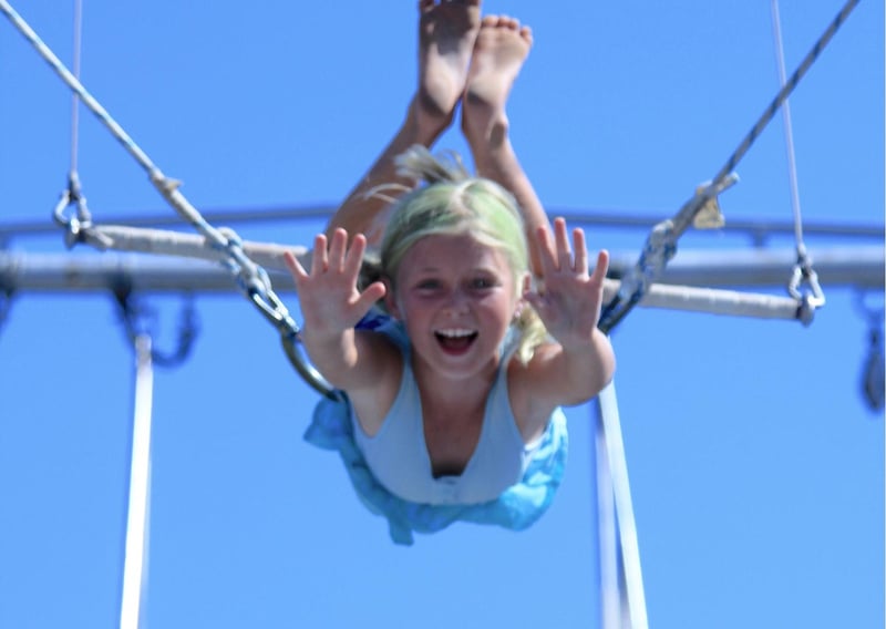 Young girl swinging from the trapeze in Circus of Arts Australia.